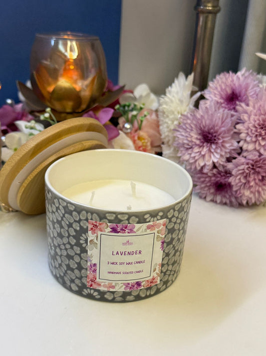 Candle in a decorative holder with a bouquet of flowers and a potted plant in the background_2